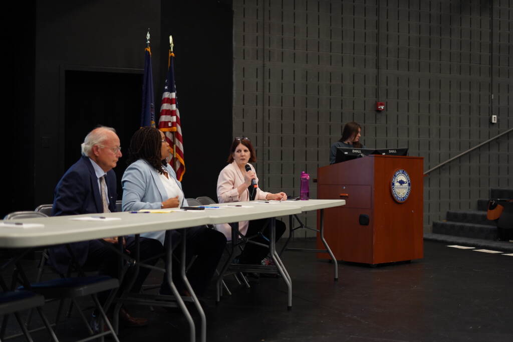 Delaware County Judge Barry Dozor, Council Chair Dr. Monica Taylor, and county Director of Human Services Sandy Garrison field questions on the the opioid settlement spending process Three people sitting at a table on a stage addressing a crowd.