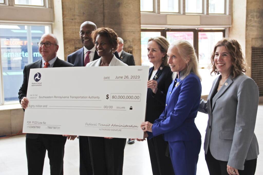 IMG_4664 (1) U.S., city, and transit leaders hold up a check for $80 million which will go towards SEPTA's goal of having a zero-emission fleet of buses