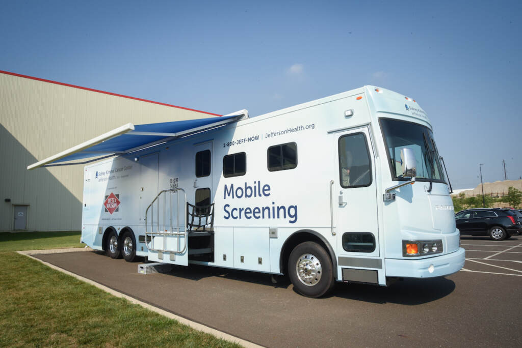 The SKCC and Dietz Watson Mobile Cancer Screening van is visible parked outside on a sunny day.