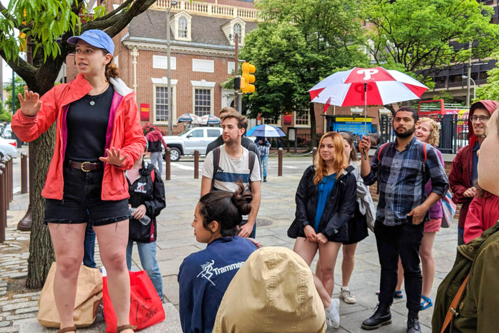 beyondthebell-walking-tour A guide speaks to a group of people gathered around her.