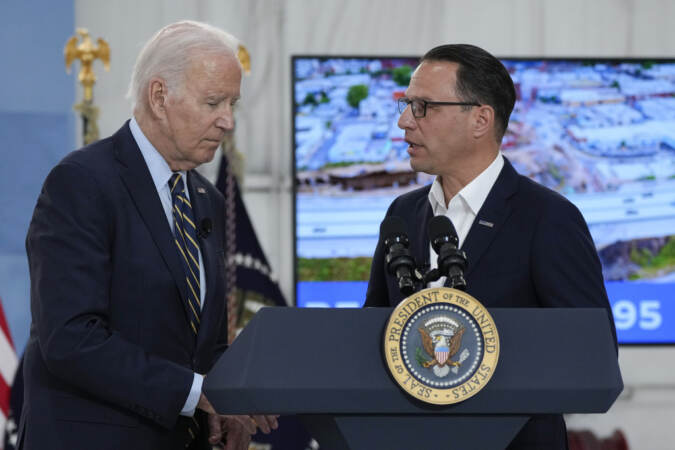 President Biden shakes Gov. Shapiro's hand at the podium.