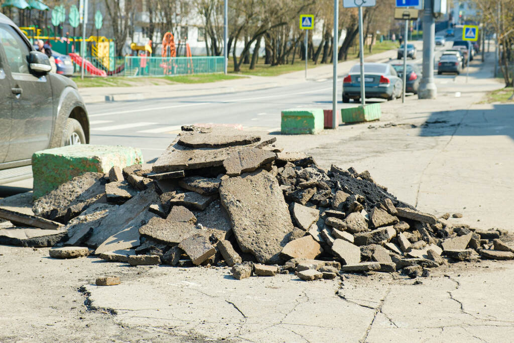 Pile of pieces of broken asphalt pavement on the side of the road during repairs.