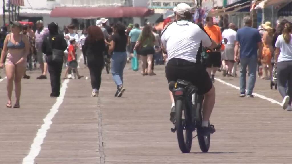 A man riding an e-bike on the boardwalk.