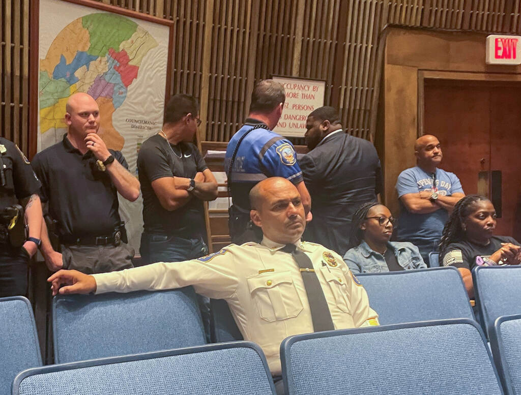 Chief Campos sitting in chairs listening to a meeting.
