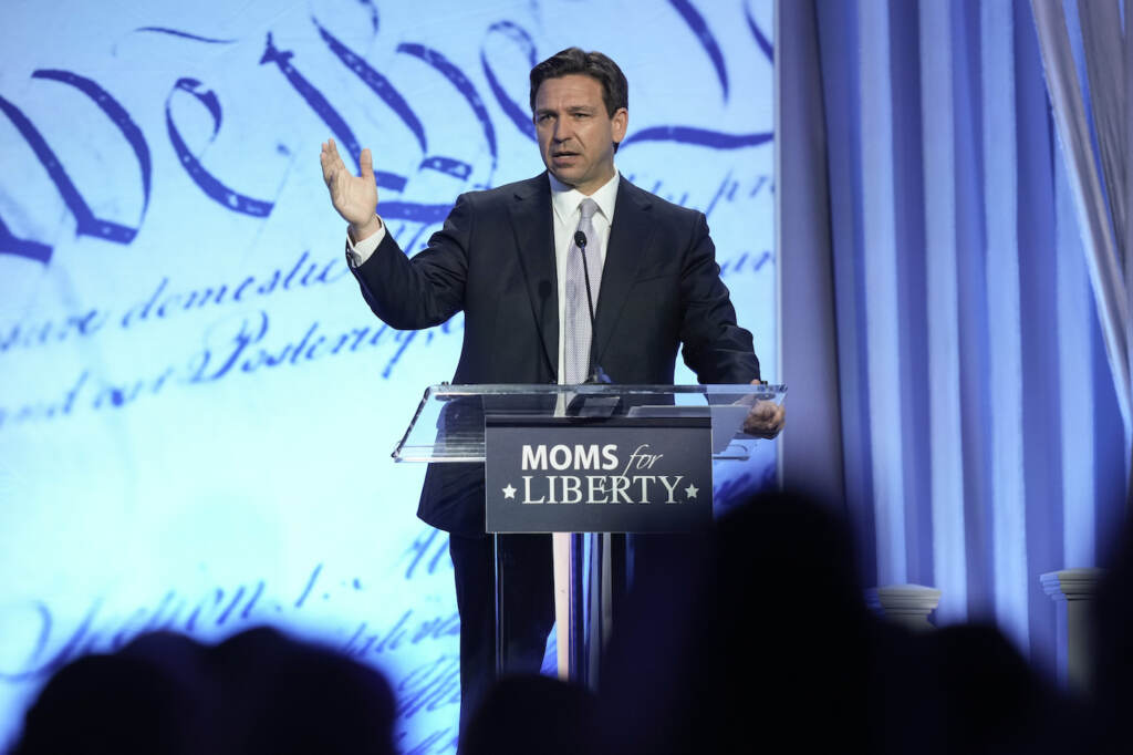 Election 2024 Moms for Liberty Ron DeSantis speaking at a podium at the Moms For Liberty conference
