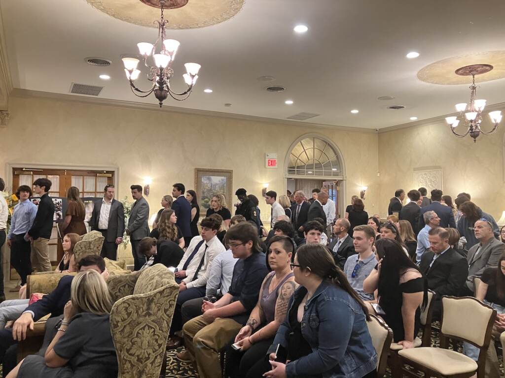 funeral-anthony-allegrini-jr-1 A room of people seated in chairs at a funeral home.