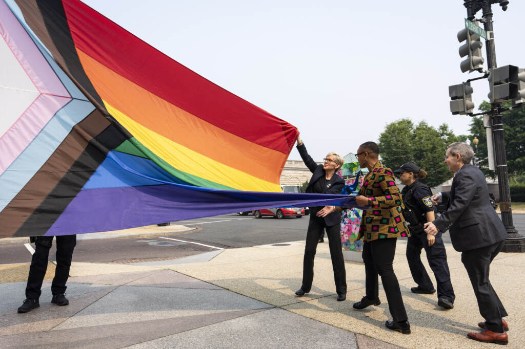 Energy Secretary Jennifer Granholm, center, helps raise a Pride flag outside of the Department of Energy as the Biden administration celebrates Pride Month.