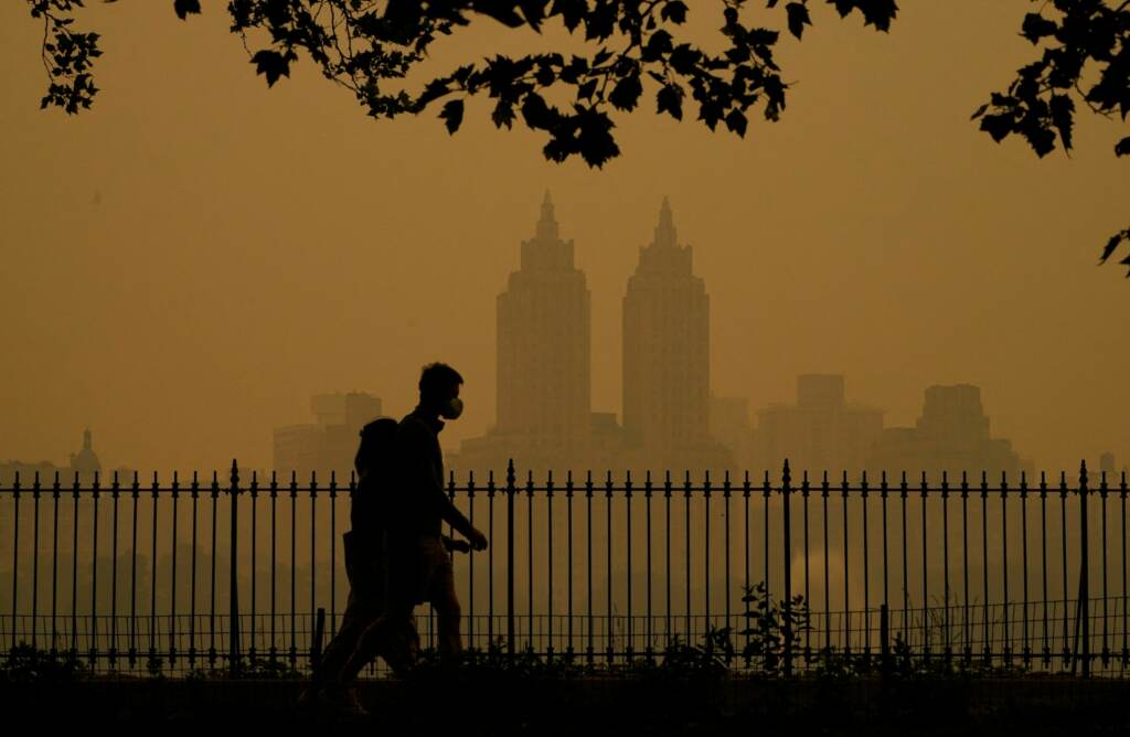 Smoky air is filled with microscopic flakes of particulate matter that can get into the lungs and even into the blood stream. People walk in Central Park as smoke from wildfires in Canada cause hazy conditions in New York City
