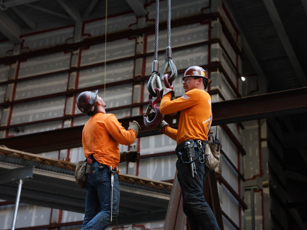 Construction workers work on a scaffolding.
