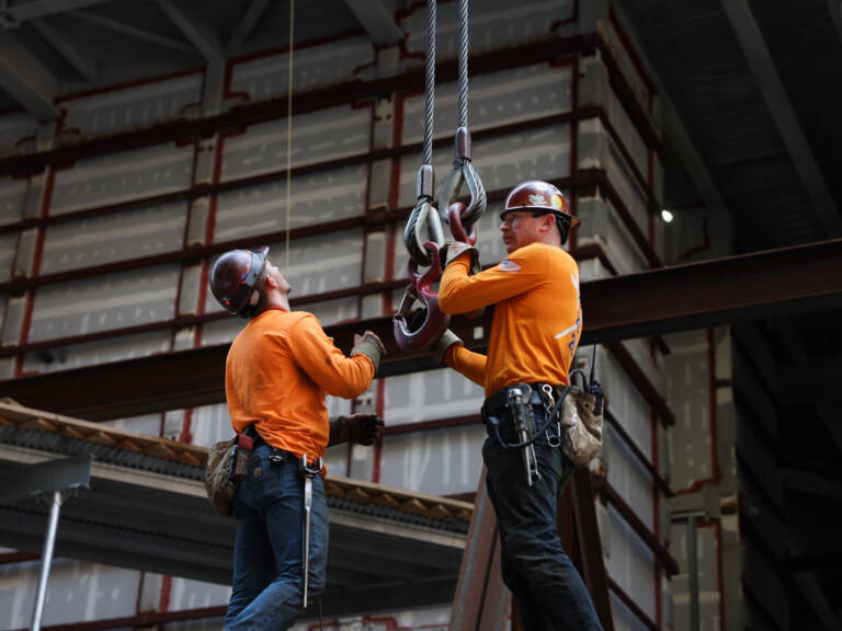 Construction workers work on a scaffolding.