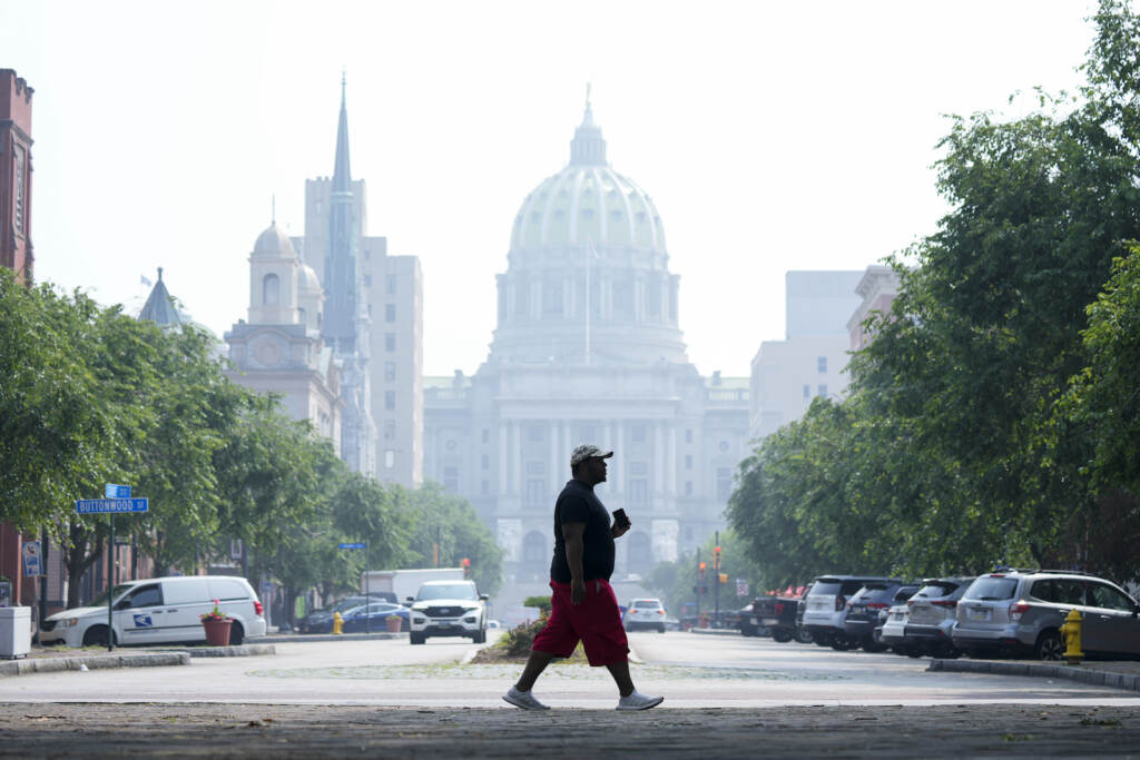 Canada Wildfire Wind Movement A person walks by the state Capitol in Harrisburg, Pa., shrouded in haze from Canadian wildfires on Thursday, June 29, 2023.