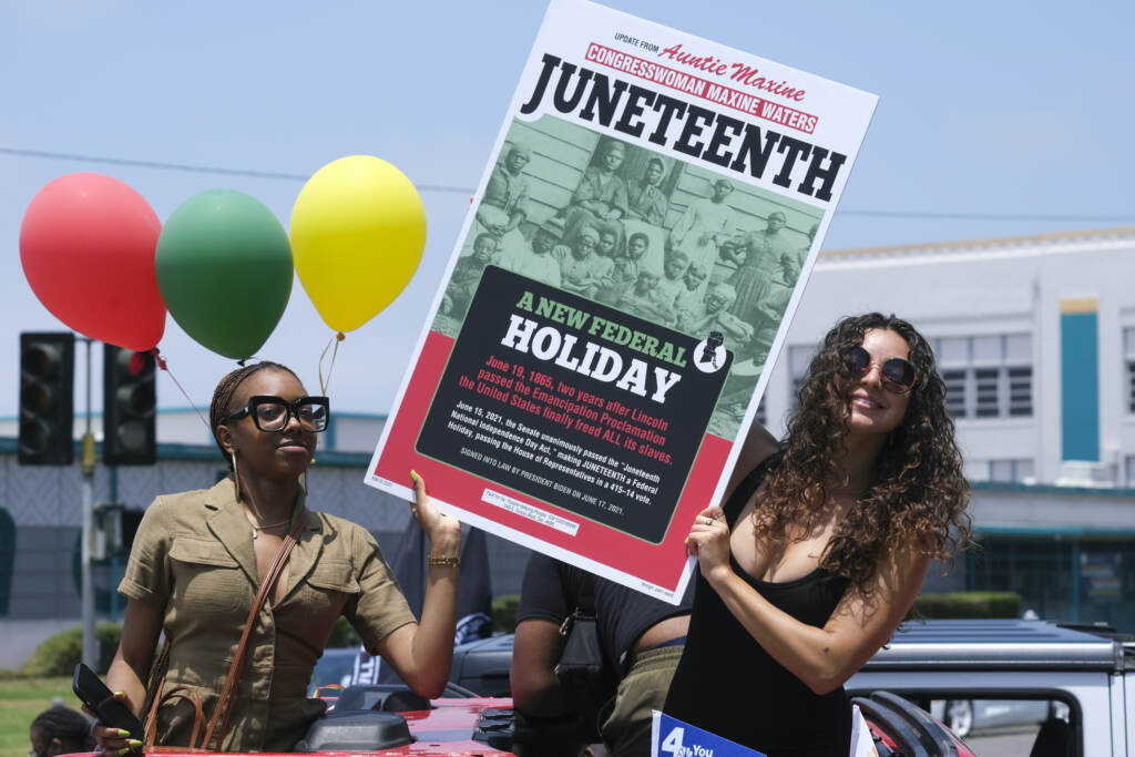 Juneteenth Explainer People holding up a sign for Juneteenth