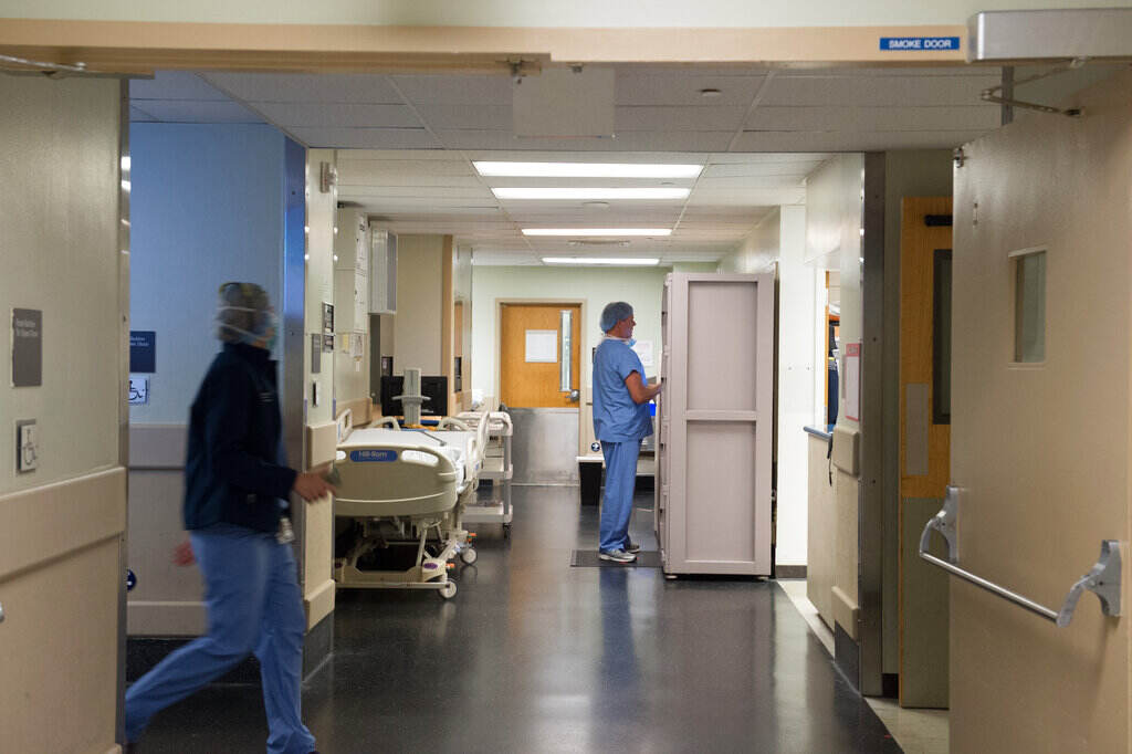 ORGAN TRANSPLANT Medical professionals walk in hallways outside of an operating room.