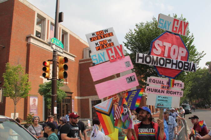 People hold up signs that read 