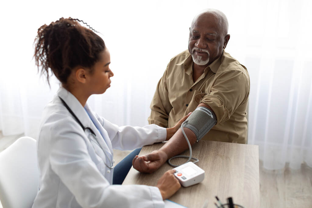 doctor blood pressure reading patient A doctor takes a man's blood pressure.