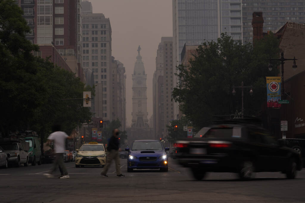 Evening commuters travel on Broad Street past a hazy City Hall, Wednesday, June 7, 2023, in Philadelphia.