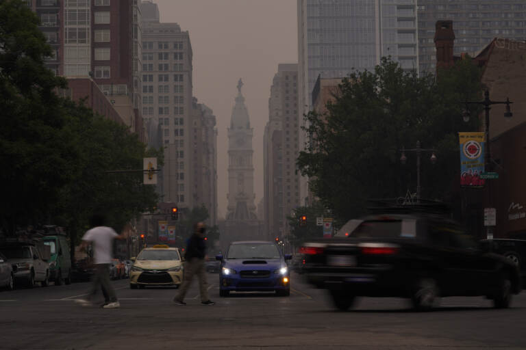 Evening commuters travel on Broad Street past a hazy City Hall, Wednesday, June 7, 2023, in Philadelphia.