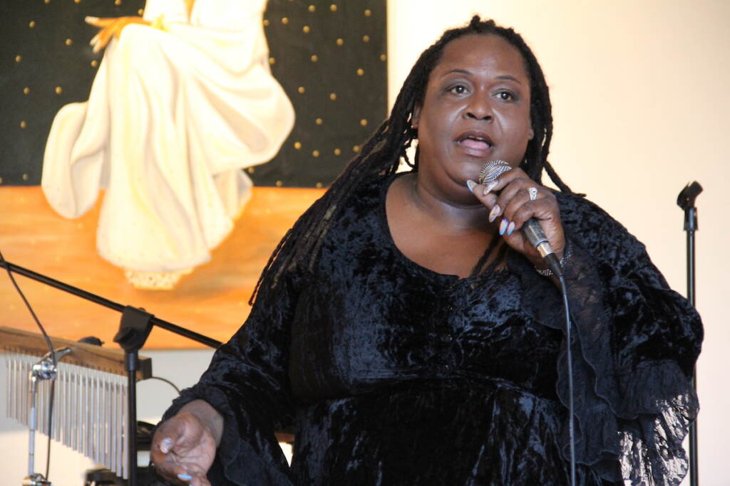 Bridges4Life Founder and CEO Tahtianna Fermin speaks into a microphone.