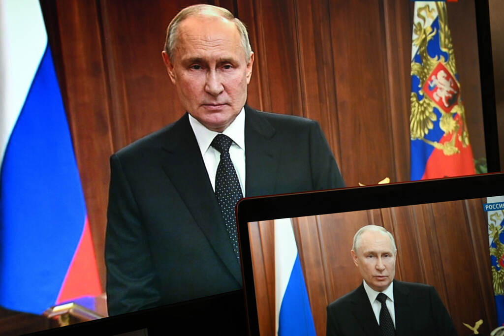 APTOPIX Russia Ukraine Putin is shown on a screen as he speaks in the background.