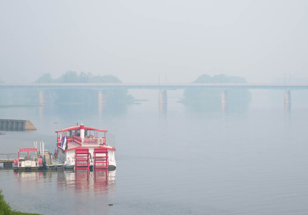 A boat on the river with very hazy sky