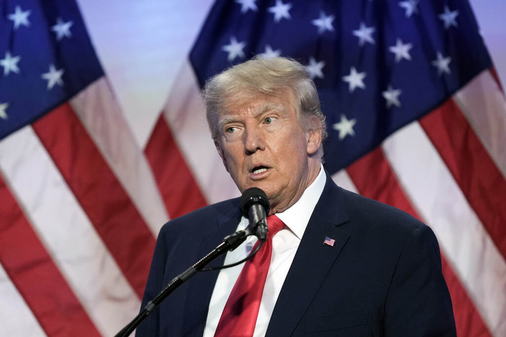 Election 2024 Moms for Liberty Trump speaks into a microphone. A U.S. flag is visible behind him.