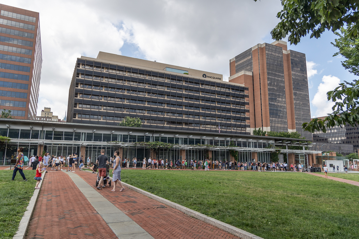 A line of people stretch across the pathway to see the Liberty Bell.