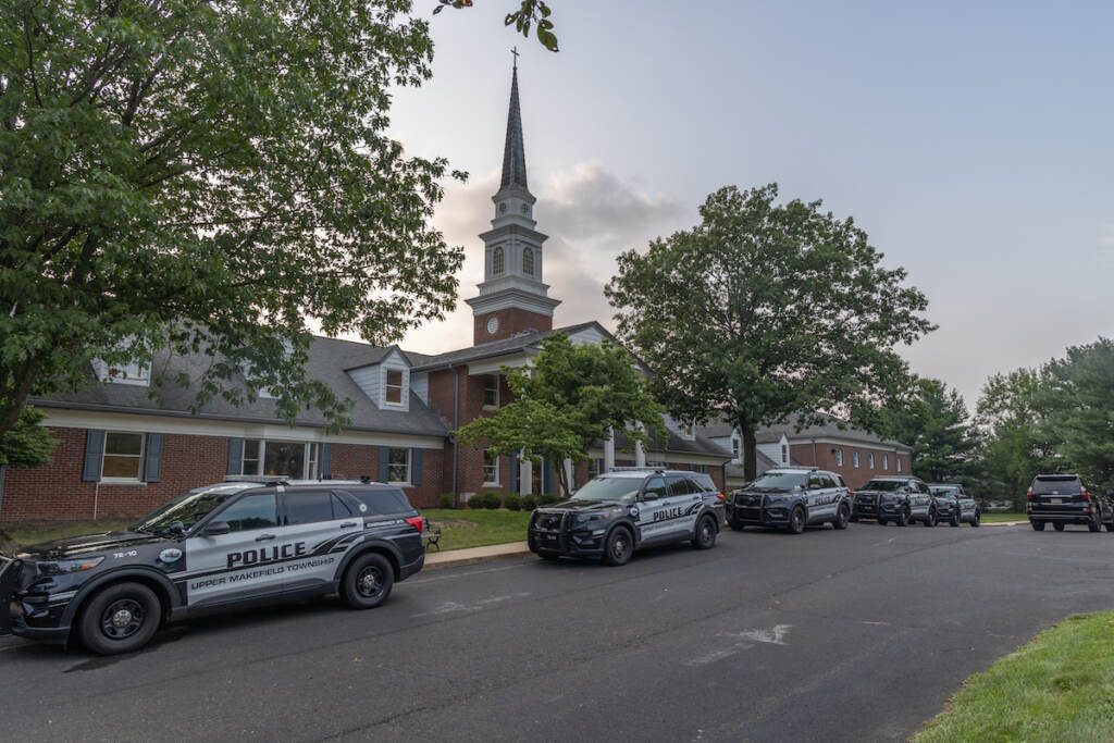 07 20 2023 k paynter flooding in upper makefield pa vigil Police cars are parked outside of a church in Upper Makefield Pa.