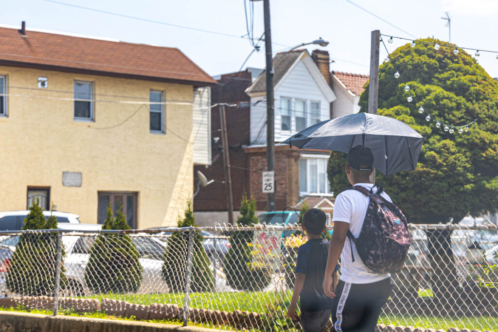 07 26 2023 k paynter heat file 2023-3 Two kids walk under an umbrella