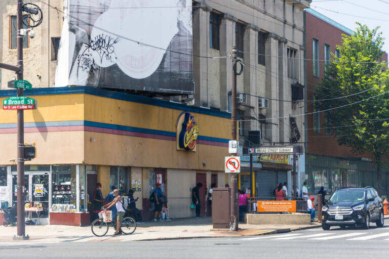 Transit riders wait for the bus in the shade at Broad Street and Erie Avenue