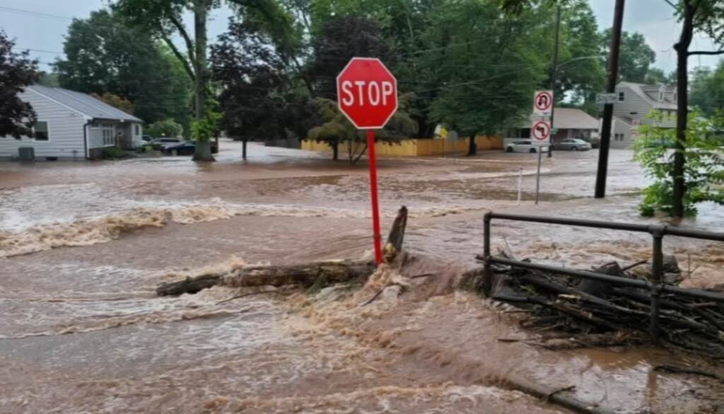13510709_071623-wpvi-bucks-county-flooding-12pm-video-CC-vid An image of a Stop sign in the middle of flooding.