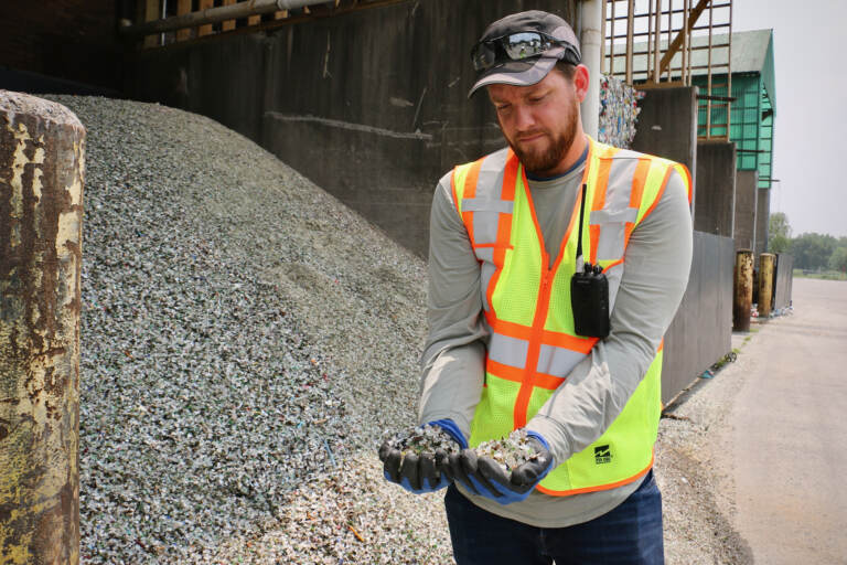 Plant manager Ryan Gregor holds handfuls of crushed glass