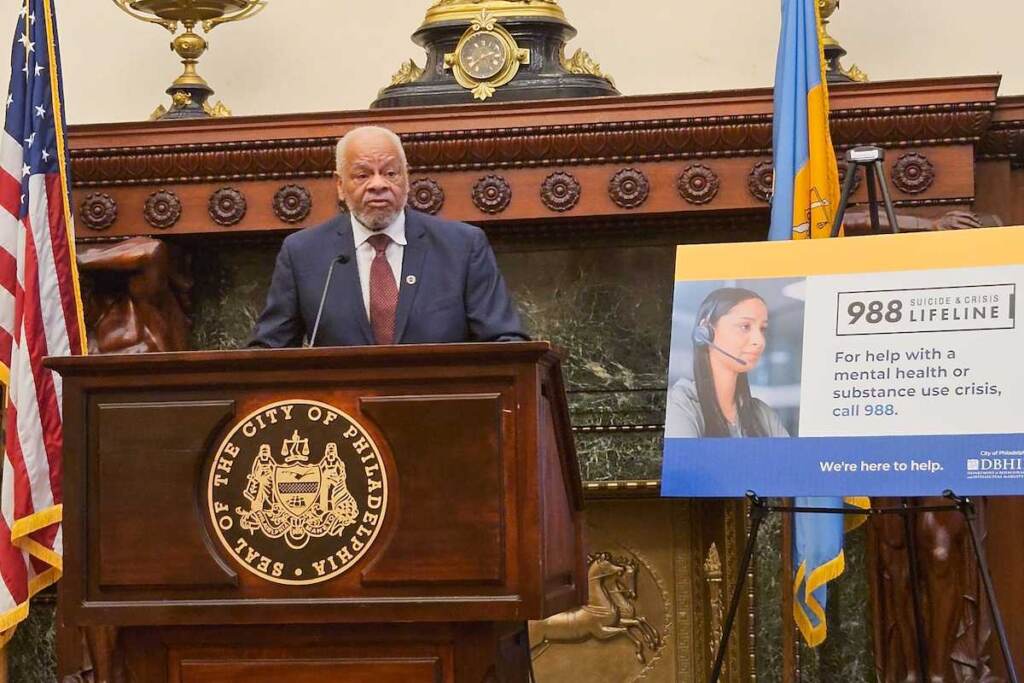 John White speaks at the podium in City Hall.