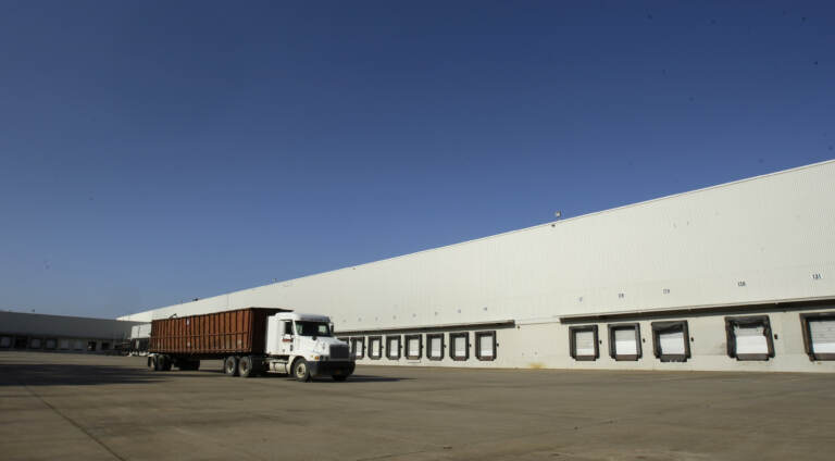 A truck drives past loading docks at a distribution center