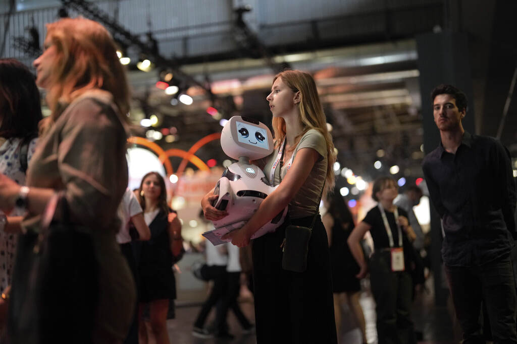 France Vivatech Show A woman carries a robot during the Vivatech show in Paris, France, Wednesday, June 14, 2023. (AP Photo/Thibault Camus)