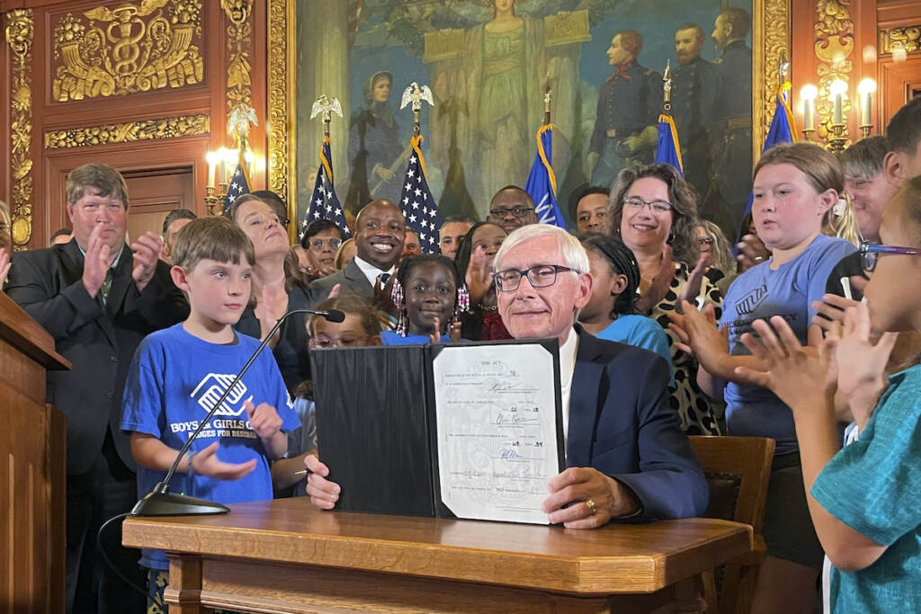 Wisconsin Budget Democratic Wisconsin Gov. Tony Evers displays a two-year budget authored by the Republicans controlled Legislature that he signed, Wednesday, July 5, 2023, in Madison, Wis. Evers used his partial veto power to remove tax cuts for the state's wealthiest taxpayers and protect 180 diversity, equity and inclusion jobs Republicans wanted to cut at the University of Wisconsin. (AP Photo/Harm Venhuizen)
