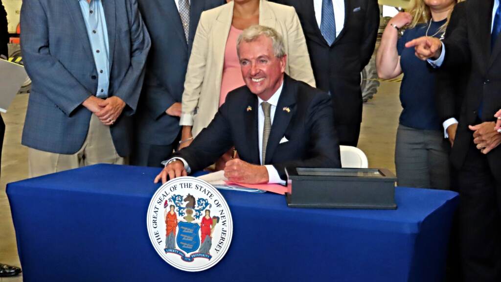 AP23187606168282 (1) New Jersey Gov. Phil Murphy signs a bill in Paulsboro, N.J., Thursday, July 6, 2023, granting a tax break to offshore wind energy developer Orsted