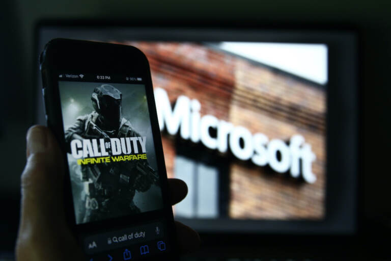 File photo: An image from Activision's Call of Duty is shown on a smartphone near a photograph of the Microsoft logo in this photo taken in New York, Thursday, June 15, 2023.