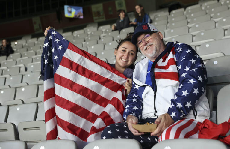 David Tritz, from Laguna Hills, California, and his daughter Erin Tritz, pose for a photo after taking their seats at the Women's World Cup soccer match between New Zealand and Norway in Auckland, New Zealand, Thursday, July 20, 2023. An estimated 20,000 Americans are coming to New Zealand for the Women's World Cup, and many have arrived in the days before the U.S. women's team plays its opener against Vietnam on Saturday