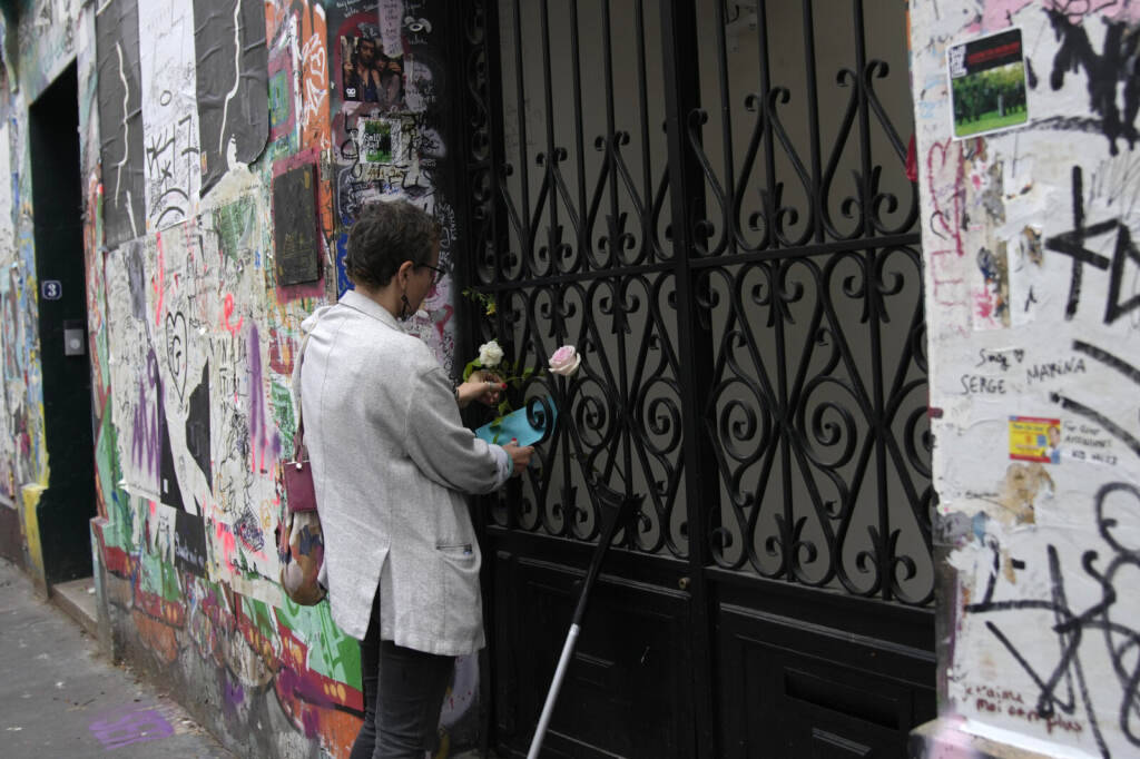 A person places flowers at the house where Jane Birkin and Serge Gainsbourg lived, on Sunday, in Paris. (Christophe Ena/AP)