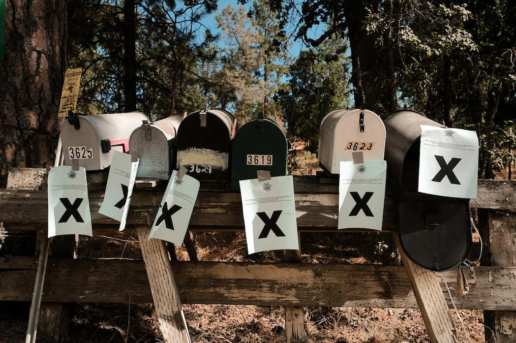 climate-change-flood-insurance-01 A row of mailboxes tagged with evacuation notices during the Oak Fire in Mariposa, Calif.