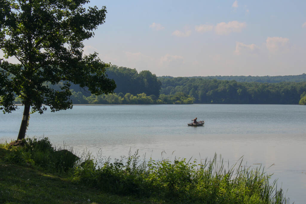 Someone in a boat in a large lake.