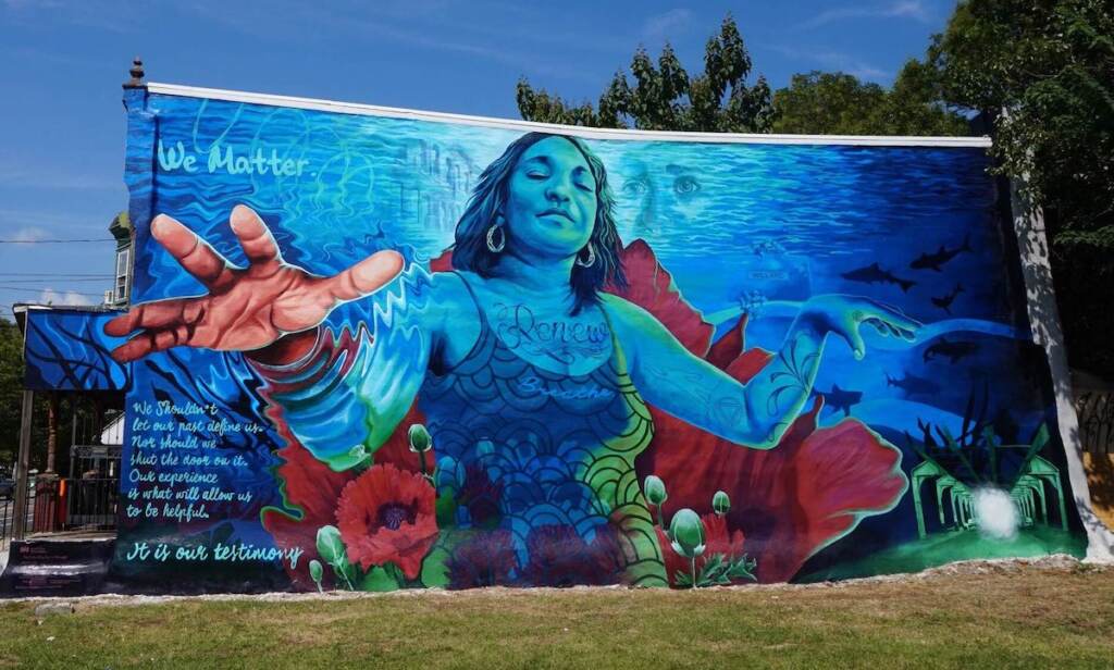 mural-the-only-way-out-is-through-philadelphia-071423 A mural depicts a person reaching out
