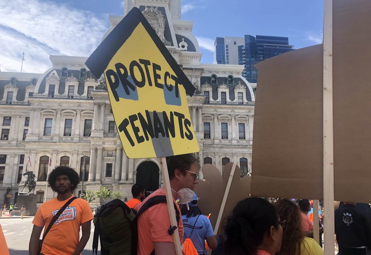 A person holds a sign that reads 