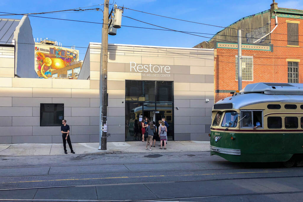 restoremarijuanapotdispensary-02b People standing outside a storefront for Restore.