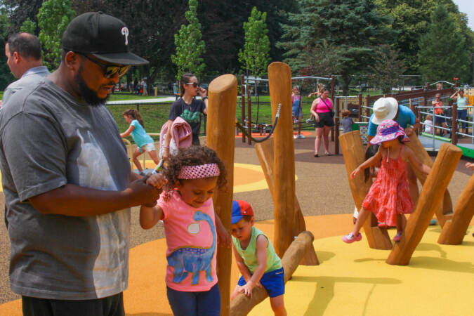 Four-year-old Marcella is accompanied by her father Harold as she plays on the structure dedicated for small kids