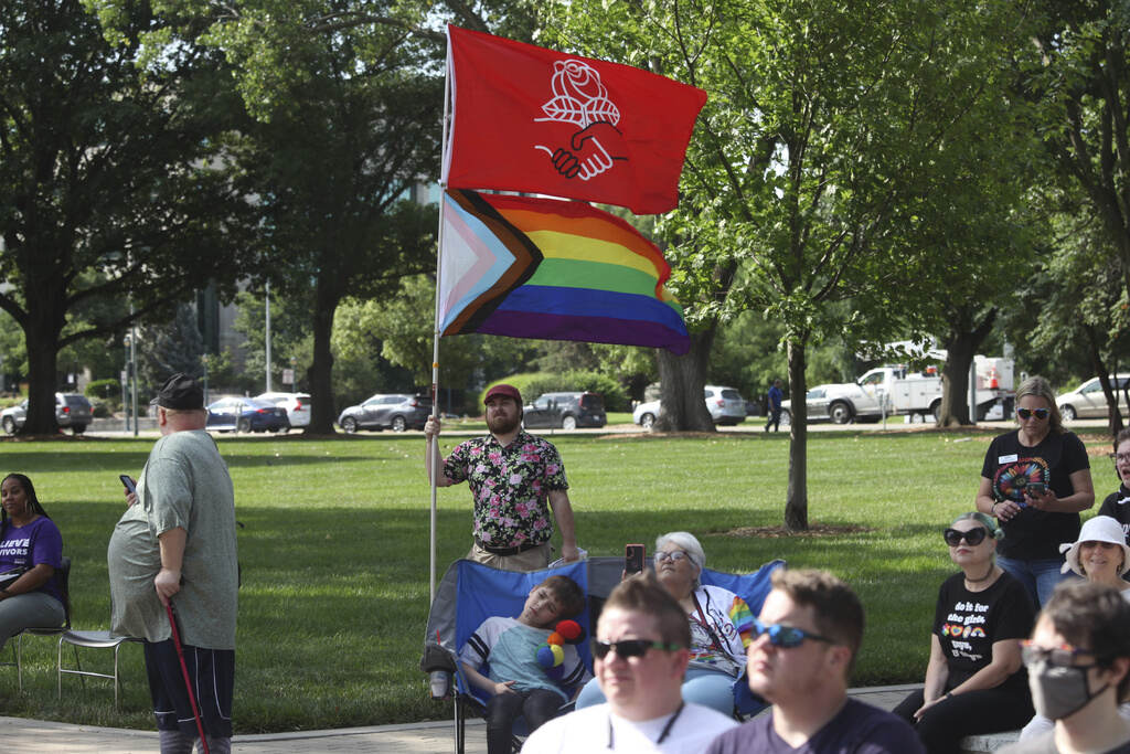 Supreme Court Gay Rights Kansas Kirby Evers, a 31-year-old bisexual Lawrence, Kan., resident, displays the red flag of the Democratic Socialists of America and a Pride flag during a rally outside the Kansas Statehouse in favor of transgender rights, Friday, June 30, 2023, in Topeka, Kan.