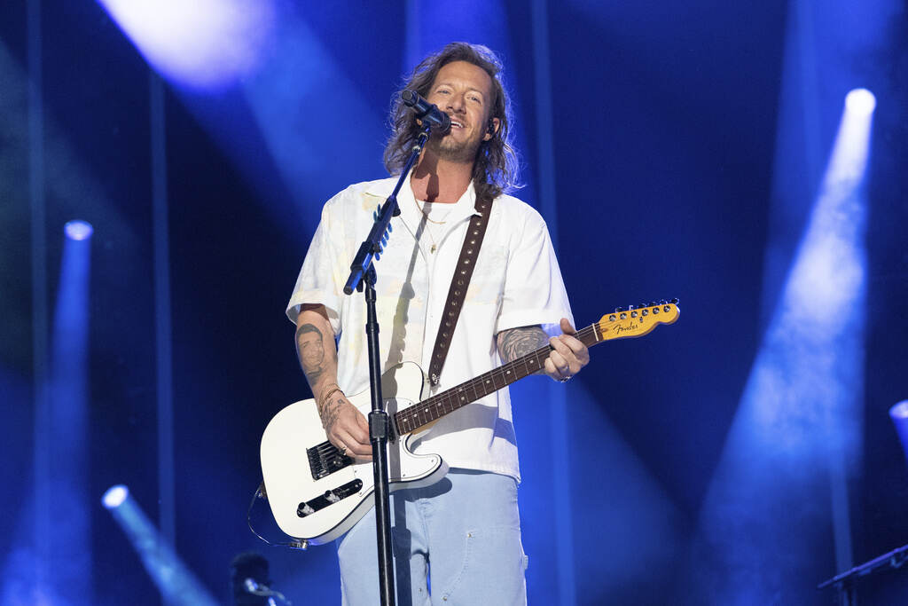 Tyler Hubbard plays guitar onstage.
