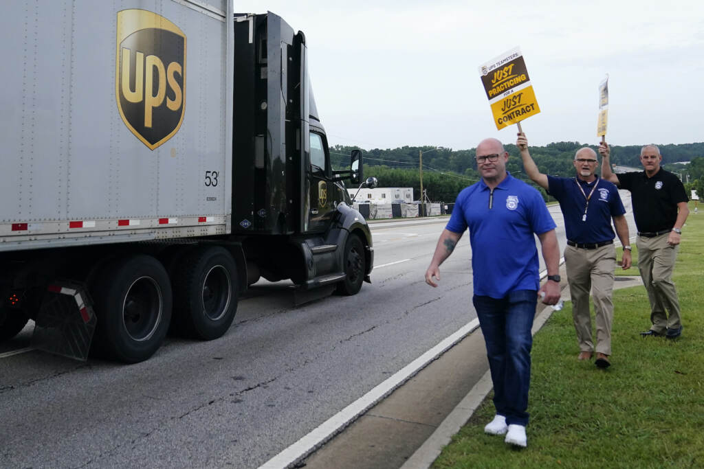 Sean M. O’Brien Workers holding up signs next to a UPS truck