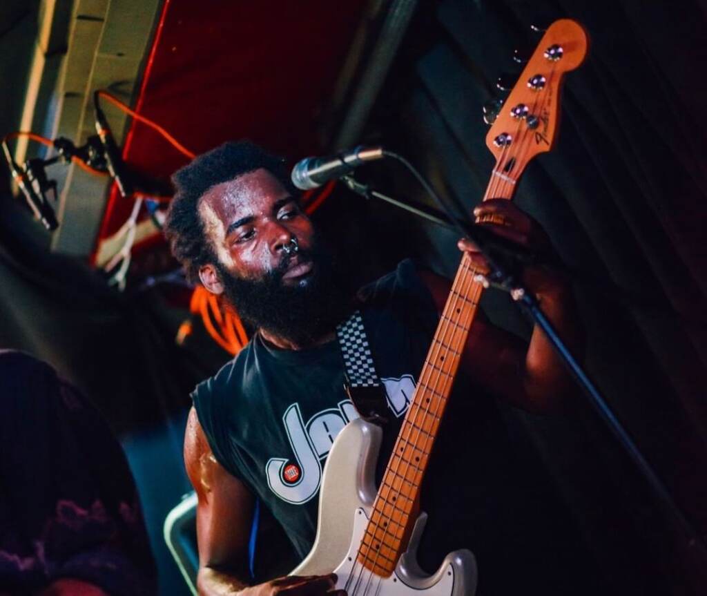 Yeho Bostick plays the guitar onstage.