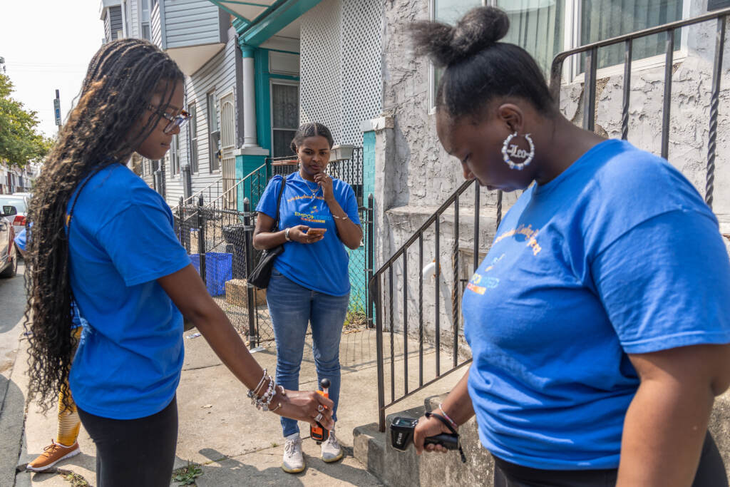 Lotus Barron (center) records the temperature, wind speed and humidity taken by Natalya Small (left) and Shiana Mitchell (right) on a summer day in Philadelphia’s Kingsessing neighborhood